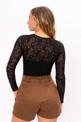 Body de encaje negro con mangas largas y espalda transparente. Presenta un diseño ajustado al cuerpo con forro en la parte frontal.