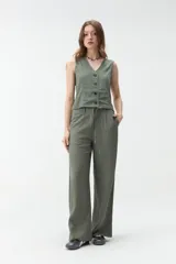 Pantalón de corte ancho y tiro medio, color verde militar, con cintura elástica ajustable mediante cordón y bolsillos laterales.