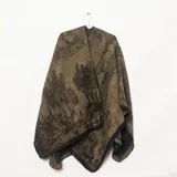 Ruana de punto color verde militar con estampado de paisaje arbolado y bordes negros.