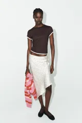 Camiseta de corte slim fit, color verde militar, con cuello redondo y manga corta. Presenta vivos de contraste blancos en el ruedo de las mangas y en el bajo.