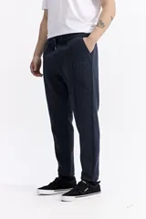 Pantalón de jogging azul marino, confeccionado en algodón y poliéster, con puños ajustados en los tobillos, elástico y cordón en la cintura, y logo estampado en el muslo.