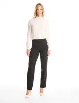 Pantalón de corte cigarette en color negro, de tiro medio-alto y largo tobillero. Confeccionado en tejido sastrero antiarrugas, presenta una silueta entallada, bolsillos delanteros con cierre metálico simulados y bolsillos traseros tipo ojal simulados.