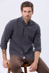 Camisa de manga larga color gris oscuro, con efecto lavado, cuello camisero con botones y cierre frontal abotonado.