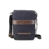 Morral de tela canvas color negro con detalles en cuero sintético marrón. Cuenta con solapa frontal con cierre magnético, bolsillo tipo guantera bajo la solapa, división interna desmontable con velcro y correa larga regulable.