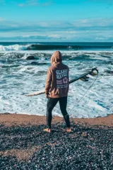 Hoodie marrón oversize con capucha y estampado en la espalda con los textos "Glassy Waves" y "Good Vibes" junto con una flor de hibisco.