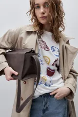 Remera color tostado de corte holgado, con cuello redondo y mangas cortas. Presenta un estampado gráfico frontal de estilo veraniego con ilustraciones de una langosta, conchas, limón, una copa y la inscripción 'Summer Club'.
