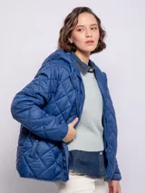 Campera capitoneada color ladrillo con capucha, cierre frontal con botones a presión y cremallera, bolsillos laterales y puños elastizados.