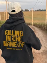Hoodie canguro con cierre frontal, color negro con efecto acid wash, con capucha y bolsillos tipo canguro. Presenta el texto estampado en amarillo "Now You Do What They Told Ya" en el pecho.