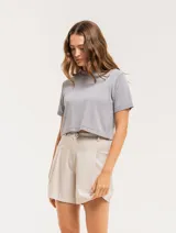 Short color beige de lino con tiro alto, elástico en la pretina trasera, cierre delantero con botón, tablas en el frente, bolsillos delanteros y dobladillo invisible.