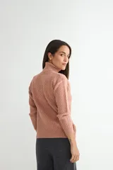 Polera de tejido de punto con cuello alto y textura acanalada en zigzag. Presenta mangas largas y puños ajustados, con un diseño clásico y versátil.