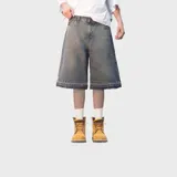 Bermuda baggy de denim color gris con efecto acid wash, corte ancho y largo por debajo de las rodillas. Cuenta con bolsillos traseros grandes con bordes deshilachados y detalle de bordado en el bolsillo derecho.