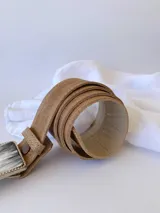 Cinto de cuero color camel con forro de cuero y hebilla rectangular de guampa con borde metálico trenzado. Cuenta con broche suizo intercambiable.