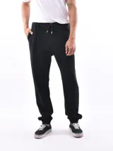 Pantalón deportivo negro, tipo jogging, con cordón ajustable en la cintura y puños elásticos en los tobillos.