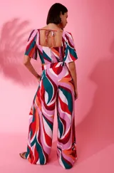 Pantalón ancho estampado de crepe, con pliegues, bolsillos laterales, bragueta con cremallera y forro interior, con diseño de ondas en tonos rosa, rojo, verde y naranja.