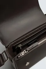 Bandolera rectangular color marrón oscuro, con solapa frontal y correa larga ajustable. Incluye un monedero pequeño en la correa.