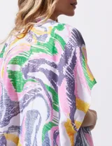 Kimono de manga amplia japonesa con estampado abstracto multicolor sobre fondo blanco. Presenta terminaciones con borlas en el ruedo.