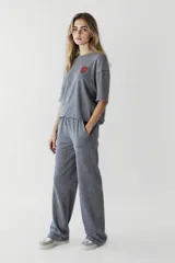 Remera de corte suelto y mangas cortas, color gris con efecto lavado. Presenta un parche circular con estampado en el pecho.