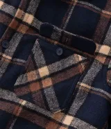 Campera tipo trucker de franela con estampado de cuadros, cuello inglés, cierre frontal con botones, bolsillos con solapa en el pecho y bolsillos laterales. Cuenta con forro interno de sherpa para mayor calidez.
