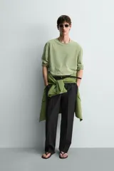 Camiseta de manga larga con ajuste relaxed fit y cuello redondo amplio, confeccionada en tejido de mezcla de algodón y lino con patrón de rayas horizontales en color verde y blanco.