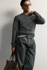Jersey regular fit de punto ligero color gris oscuro, tejido en hilatura de lana con cuello redondo, manga larga y acabados en rib.