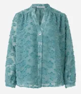 Camisa celeste en tejido chiffon con textura de bordado con felpas, cuello mao, abotonadura frontal y mangas largas abullonadas.