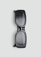 Lentes de sol Nimes con montura rectangular de policarbonato negro y detalles metálicos de cobre.