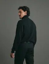 Polera de punto de manga larga en color azul marino, con cuello alto doblado y puños y ruedo acanalados.