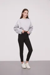 Calza negra de tiro alto con cierre lateral y detalle de costura en la rodilla.