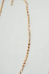 Set de tres collares dorados de diferentes diseños: uno con corazones y perlas, otro de eslabones y el último de cadena fina.