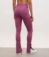 Pantalón deportivo tipo legging flare de tiro alto, confeccionado en microfibra con abertura lateral en el ruedo.