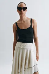 Musculosa de escote redondo y tirantes finos, confeccionada en tejido rib con ajuste entallado.