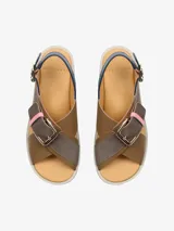 Sandalia de cuero con tiras cruzadas, base de goma espuma esculpida y hebillas metálicas.