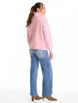 Buzo de punto grueso con textura en relieve, de cuello volcado y mangas largas con hombros caídos. Presenta puños y ruedo con terminación en rib.