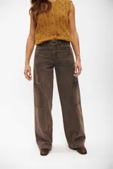 Pantalón tipo jean de corte cargo, color marrón con efecto lavado. Presenta costuras verticales decorativas, bolsillos laterales y diseño de pierna ancha.
