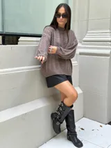 Sweater marrón tejido con diseño de ochos y cuello alto.