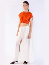 Remera color naranja de manga corta, confeccionada en algodón, con detalles de flecos y bordado en las mangas.