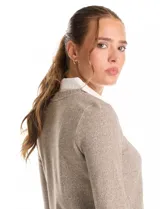 Buzo combinado marca Rio & Rian, con diseño de efecto capas que simula una camisa blanca debajo. Presenta un cuerpo de tejido de hilado fino en color beige con escote en V, y cuello y ruedo de gasa blanca.