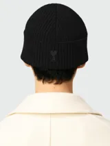 Gorro tipo beanie de lana en color negro, con diseño de punto acanalado y vuelta en el borde.