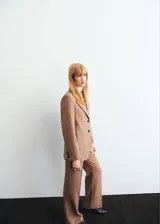 Pantalón Natalie de tiro medio y diseño recto, confeccionado en mezcla de poliéster y lana. Cuenta con bolsillos laterales, bolsillos posteriores de ribete y cierre frontal oculto con botón, gancho y cremallera.