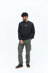 Buzo de algodón color negro lavado, con cuello redondo y estampado frontal en blanco con texto que incluye "BROOKSFIELD COVENT GARDEN LON UK". Presenta un pequeño parche negro en la manga izquierda.