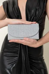 Sobre de fiesta plateado con detalle plisado en el frente. Incluye cadena plateada para colgar o llevar en la mano.