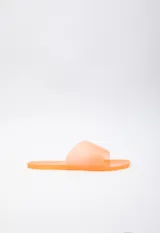 Sandalia chata color naranja de goma semi transparente con tira ancha sobre el empeine.