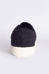 Zapatillas casuales color mostaza con cordones negros y suela blanca.