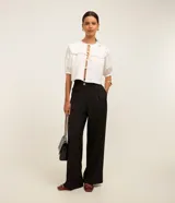 Pantalón de vestir negro, de corte wide leg, con cintura alta, bolsillos laterales y traseros.