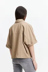 Camisa color beige de manga corta con cuello clásico y corte oversize.