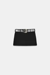 Falda pantalón negra de tiro medio con cierre frontal y hebilla metálica. Presenta bolsillos delanteros y falsos bolsillos de vivo en la espalda.