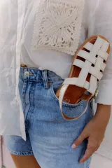 Sandalias tipo huarache de cuero con diseño de tiras entrelazadas, punta cerrada y cierre con hebilla lateral. Cuentan con suela plana y plantilla con logo grabado.