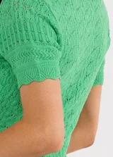 Sweater tejido verde esmeralda con cuello polo, manga corta y cierre frontal de botones plateados.