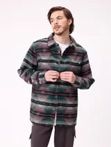 Camisa de manga larga con diseño de estampado étnico en tonos azules y beige. Presenta cuello clásico, cierre frontal con botones y bolsillos en el pecho.