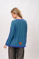 Sweater tejido de punto con franjas verticales azules y verdes, de corte holgado y mangas largas.